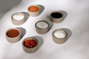 pexels-photo-5899677-5899677-2 Variety of sauces and dips in rustic ceramic bowls under natural sunlight.