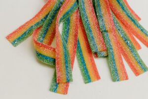 pexels-photo-7110203-7110203 Colorful rainbow sour candy strips in a studio close-up, showcasing sugary sweetness.